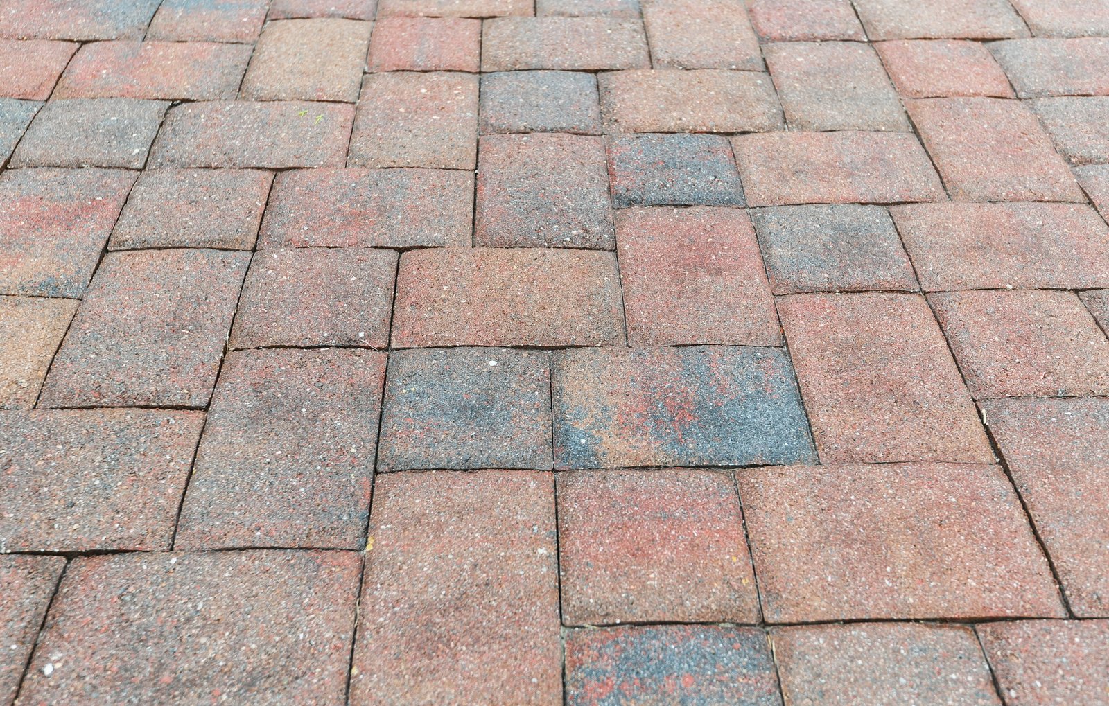 Older paving in a driveway that needs new sealant to protect it from the elements.